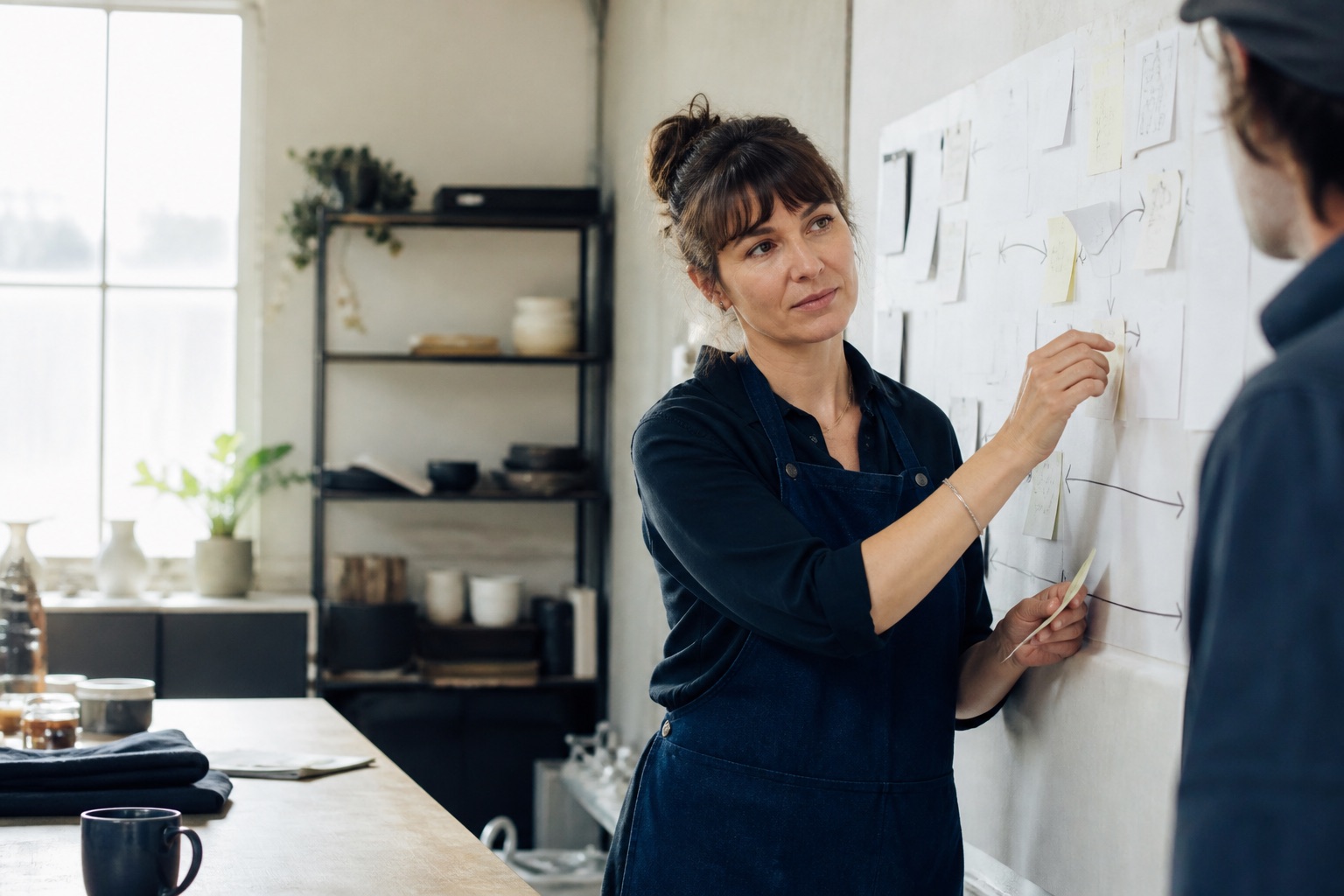 Small-business owner mapping a practical workflow with a colleague